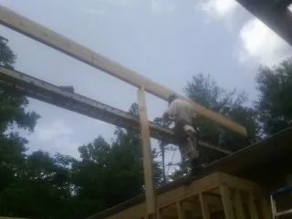 Carpenter setting a ridge beam over a new addition frame — Ice Dam Removal by Roofing Brothers in Canadensis