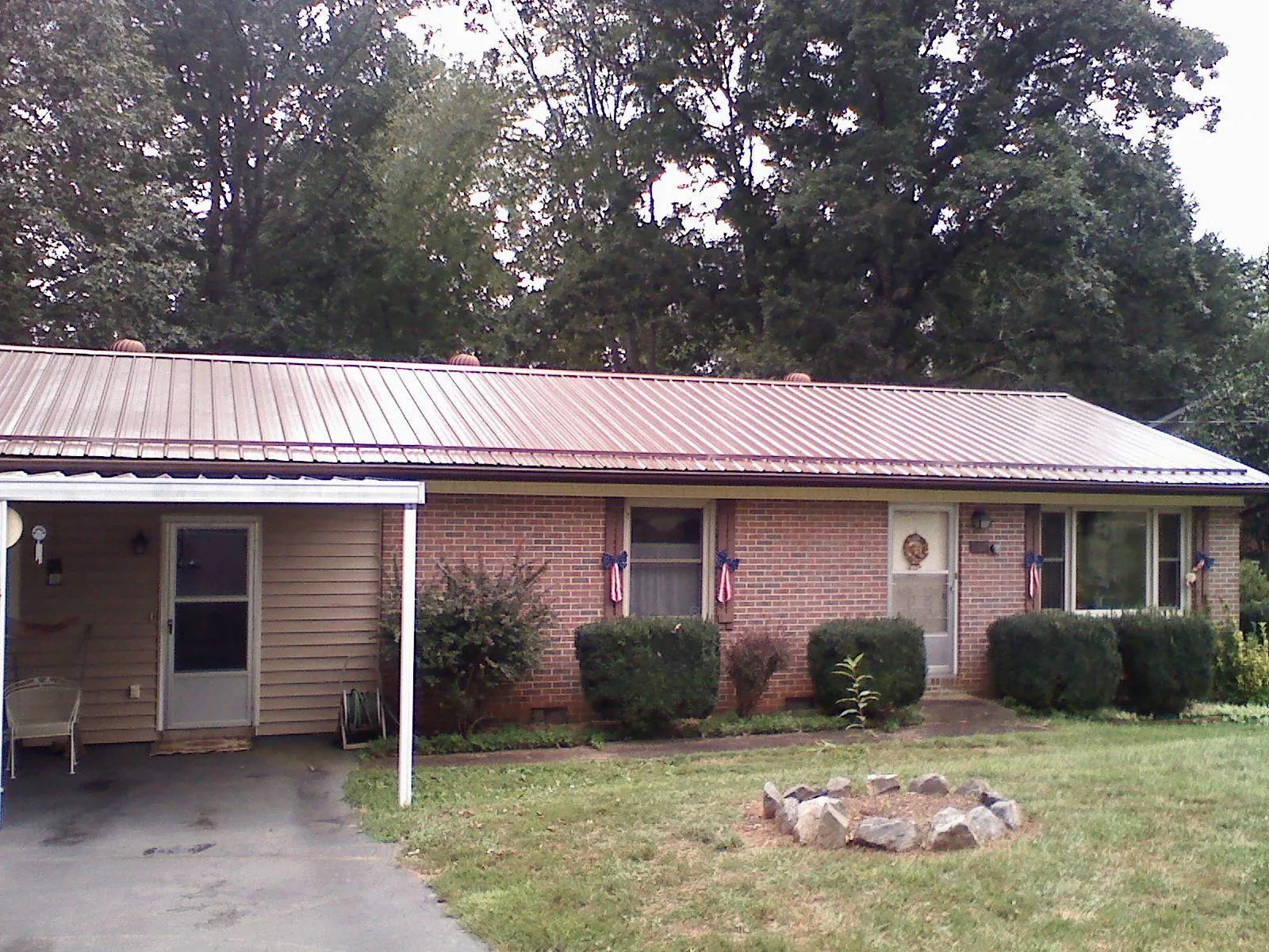 Bronze metal roof and carport on a brick ranch home — Roof Repair work by our crew in Canadensis